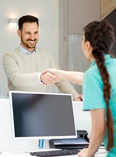 man shaking front desk hand