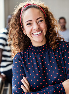 Smiling woman in office showing her dental bridge in Topeka, KS