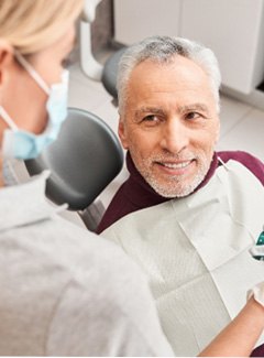 An elderly man who qualifies for dentures