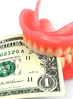 Dollar bill held by dentures in Topeka & Silver Lake, KS