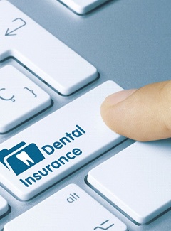 Finger pressing a key that says “Dental Insurance”