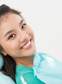 Happy, smiling dental patient in treatment chair