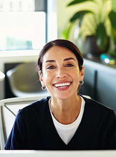 Smiling dental team member behind desk