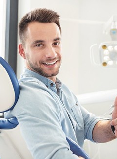 man giving a thumbs-up in the dental chair 