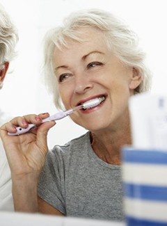 elderly couple brushing their teeth together 