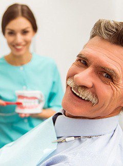 Man smiles after getting dental implants in Topeka