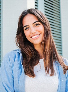 Woman with white teeth smiling while standing outside