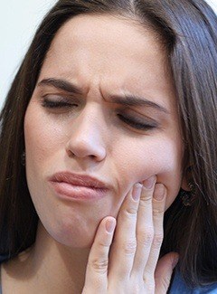 woman in pain with eyes closed